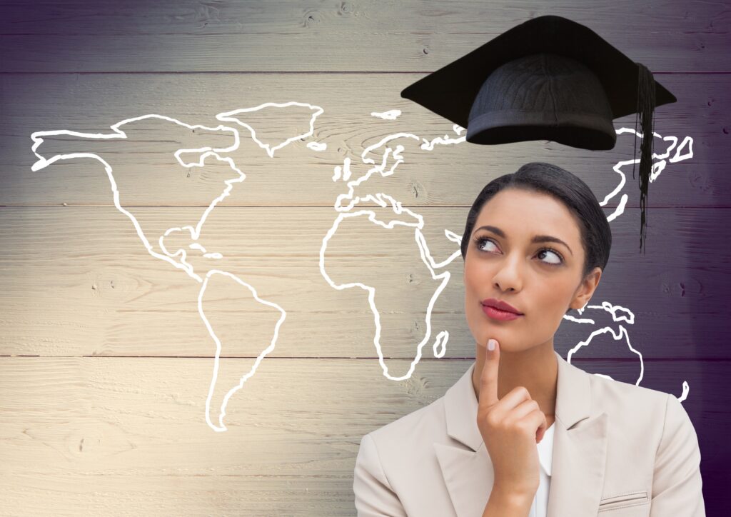 Thoughtful businesswoman with graduation cap and world map on wooden plank background